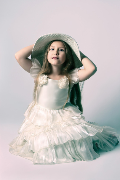 Gyönyörű gyermek lány fehér ruhában és kalapban. - Fotó, kép