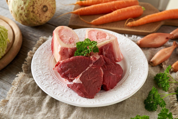 Ингредиенты для приготовления домашнего бульона или супа - мясо говядины, кости костного мозга и овощи - Фото, изображение