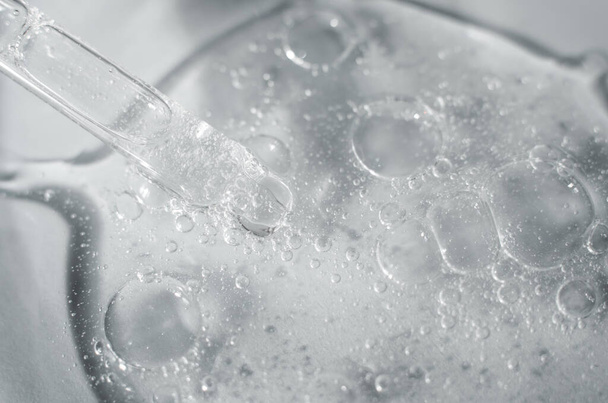 Átlátszó kozmetikai aloe vera gél Petri-csészében pipettával. Makro fénykép egy gél szerkezetét buborékok. - Fotó, kép