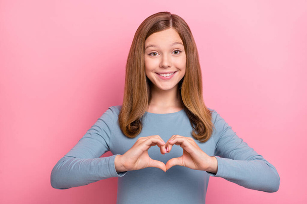 Photo of flirty blond teen girl show heart wear blue shirt isolated on pink color background - Foto, Bild