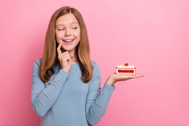 Portrait of attractive cheery curious brown-haired girl holding on palm berries pie thinking isolated over pink pastel color background - Fotó, kép