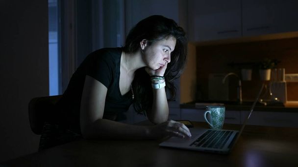 Person, die nachts online Inhalte vor dem Laptop-Bildschirm liest - Foto, Bild