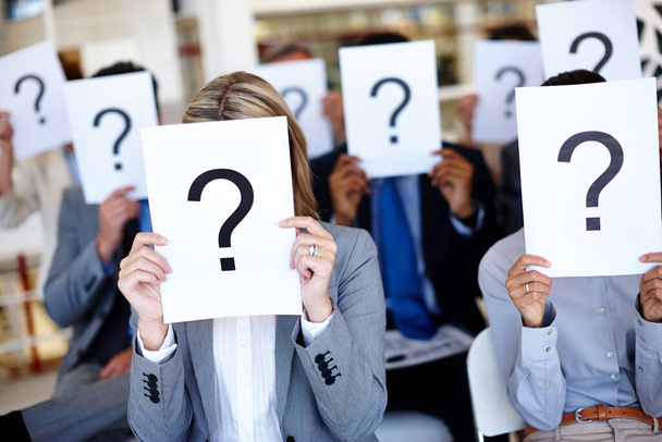 Dont be afraid to own your voice. Shot of a group of businesspeople holding up signs with question marks on them during a work presentation. - Foto, Bild