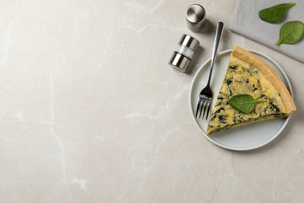 Piece of delicious spinach pie served on light marble table, flat lay. Space for text - Фото, изображение