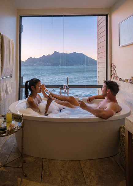 Paar Mann und Frau in Badewanne mit Blick auf den Ozean von Kapstadt Südafrika im Urlaub - Foto, Bild