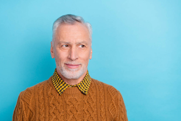Photo of cute thoughtful man pensioner dressed brown pullover looking empty space isolated blue color background - Foto, imagen