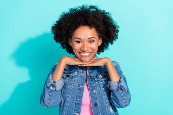 Photo of sweet cute young woman wear jeans jacket arms chin smiling isolated turquoise color background - Fotoğraf, Görsel