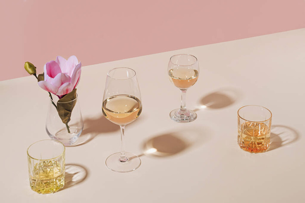 Assorted beverages or alcoholic drinks served in stylish glasses with flower on table with copy space - Fotó, kép