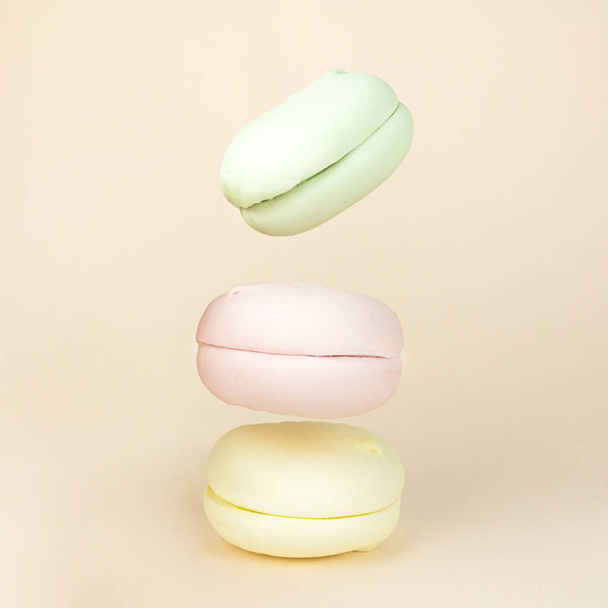 Different types of marshmallows looks like macaroons in motion falling on pastel beige background. Small French cakes - Valokuva, kuva