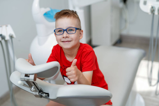 Усміхнена дитина грає з стоматологічним обладнанням. маленький лікар стоматолог хлопчик
. - Фото, зображення