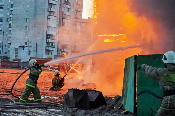 Bomberos apagan un fuego en una casa de madera de dos pisos - Foto, Imagen
