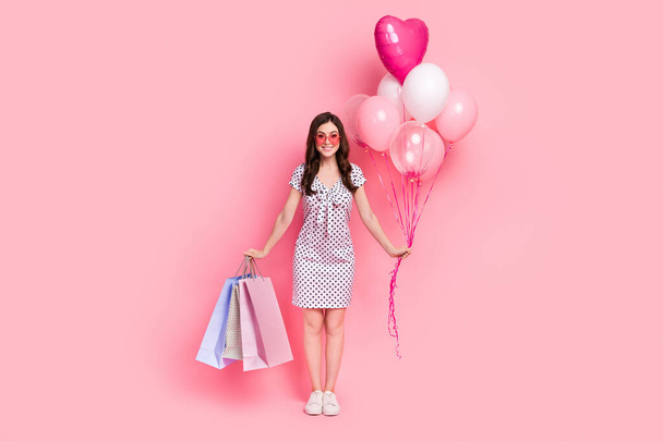 Photo of sweet cute woman wear white dress heart glasses holding air balls shoppers isolated pink color background - Foto, immagini