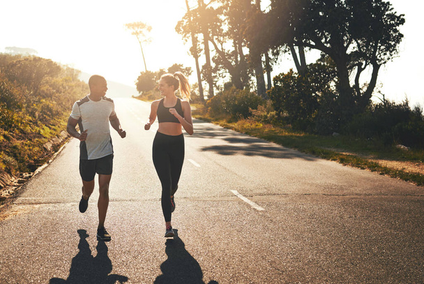 Getting the blood flowing with a workout buddy. Shot of a fit young couple going for a run outdoors. - Foto, immagini