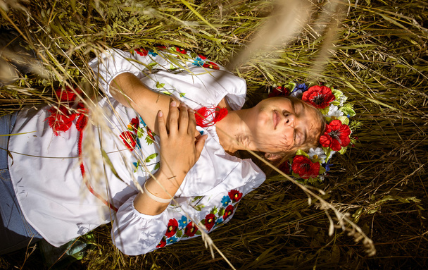 woman in national ukrainian clothes with closed eyes lying on fi - Photo, Image