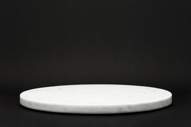 empty round marble tray on black background for presentation of various products, stone podium concept - Photo, Image