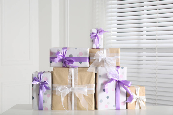 Heap of wrapped gift boxes on white table. Happy holiday - Photo, Image