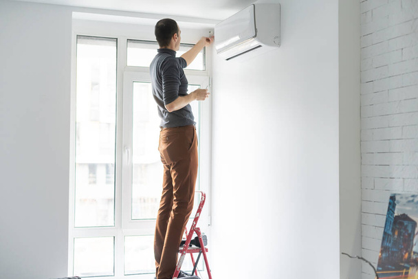 屋内で現代のエアコンを維持する専門の技術者 - 写真・画像