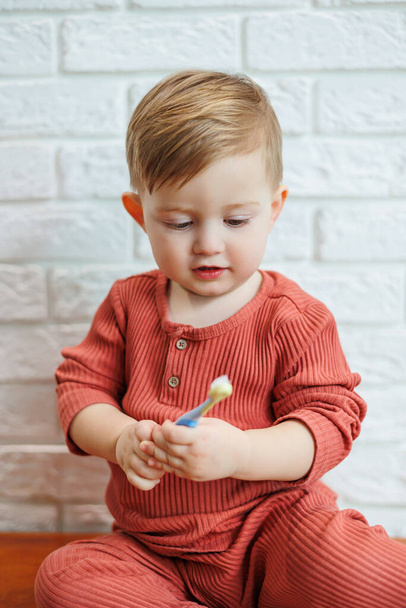 Un bambino piccolo impara a lavarsi i denti con uno spazzolino da denti. Igiene dentale nei bambini - Foto, immagini