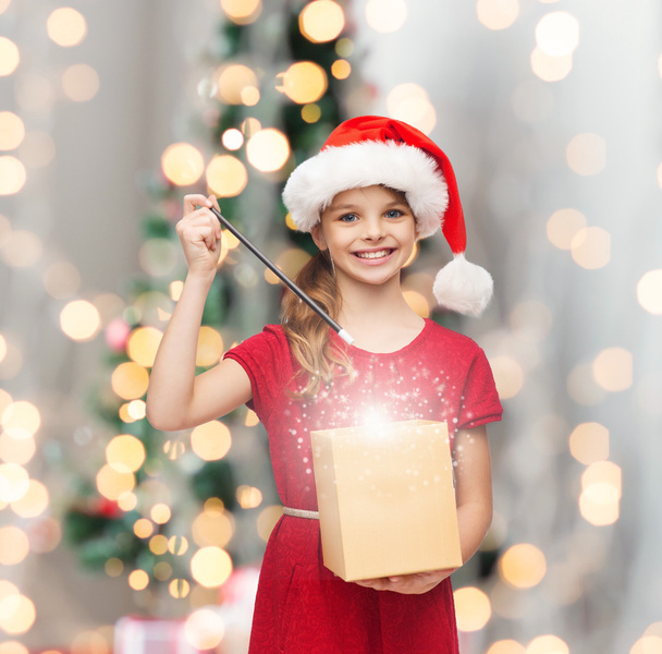smiling girl in santa helper hat with gift box - Photo, Image