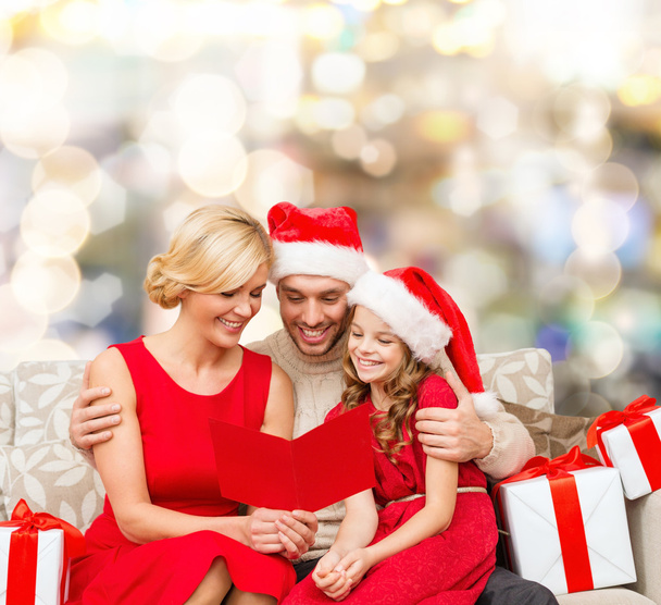 happy family in santa helper hats with gift boxes - 写真・画像