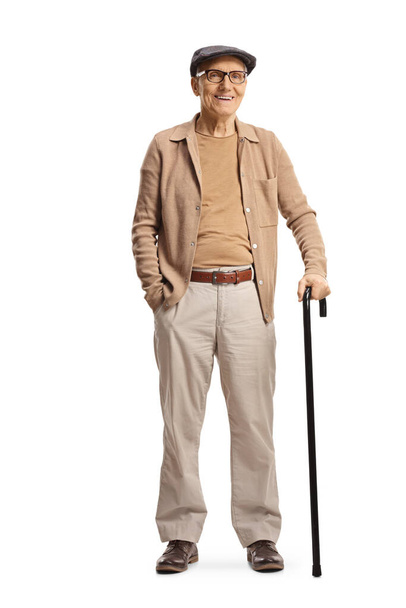 Full length portrait of a smiling elderly gentleman standing with a cane isolated on white background - Фото, изображение