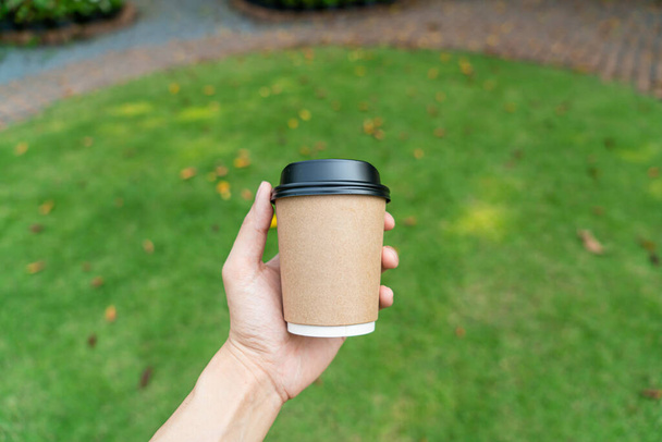 hand holding hot coffee in takeaway glass - Foto, imagen