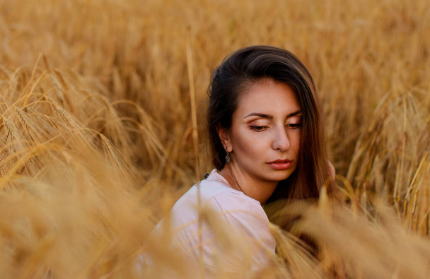 Молодая красивая девушка на пшеничном поле. сексуальная женщина в золотой пшенице - Фото, изображение