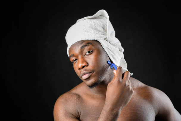 adult african man with towel shaves on black background - Foto, Imagem