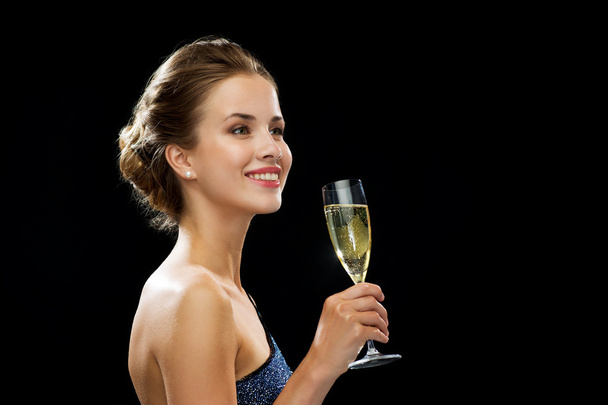 smiling woman holding glass of sparkling wine - 写真・画像