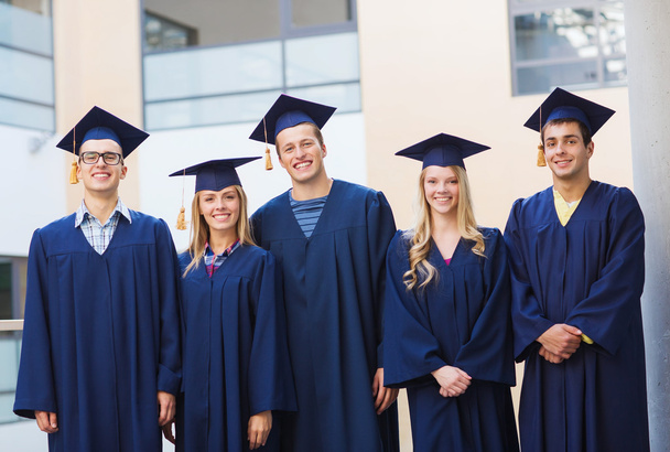 group of smiling students in mortarboards - Фото, изображение