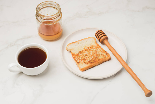 Croutons for breakfast with honey and coffee on a white background. Top view. - 写真・画像