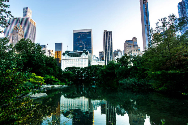 ニューヨーク、米国のセントラルパークの眺め。池、多くの緑、高層ビル、 - 写真・画像