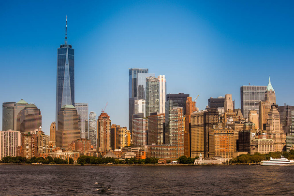 Cityscape of Manhattan from a ferry boat in New York, USA. Multiple skyscrapers in city downtown, water - Foto, Imagen