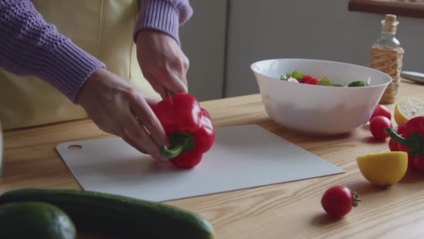 Женщина нарезает красный сладкий перец - Кадры, видео