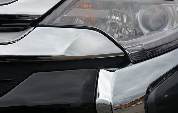 Parte della parte anteriore di una macchina grigia come sfondo, scatto ravvicinato, modello Giappone - Foto, immagini
