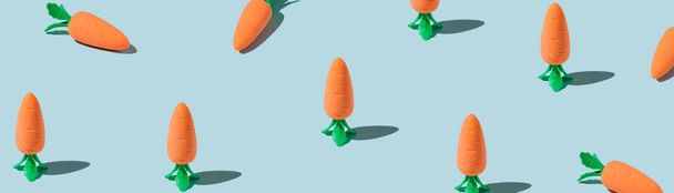 Banner made Easter pattern made with carrots on blue background. Creative minimal holiday concept. Flat lay, top view - Φωτογραφία, εικόνα