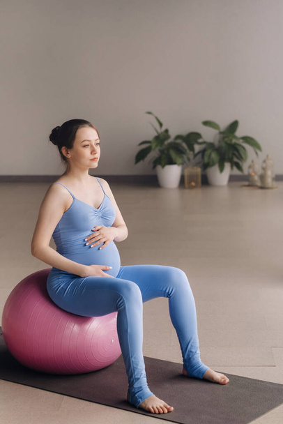 Pregnant woman during fitness classes with a fitball. - Valokuva, kuva
