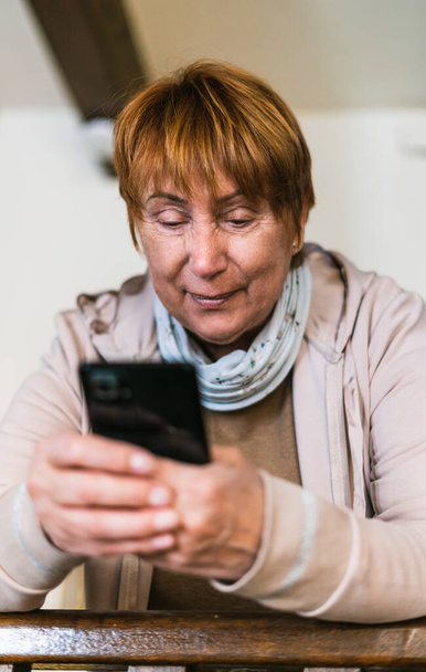 Nonna cerca telefono cellulare in soggiorno - Foto, immagini
