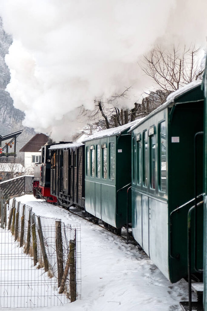 Vista do trem a vapor em movimento Mocanita de dentro dele, aldeia no inverno, neve, Romênia - Foto, Imagem