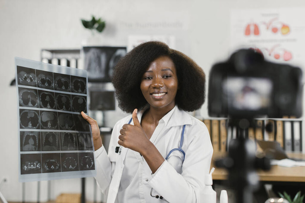 African female doctor showing x ray scan while filming vlog - Valokuva, kuva