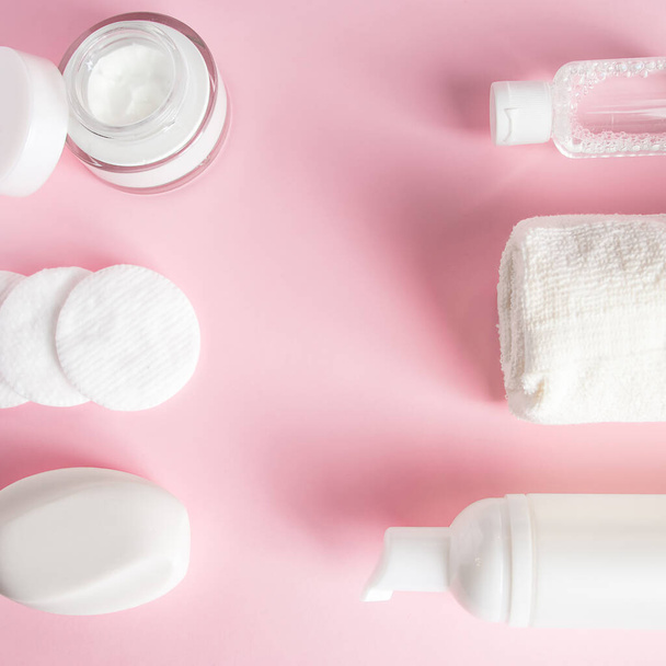 Cosmetic products on pink background. Soap, lotion, and cotton pads. Spa accessories. Wellness concept. - Photo, Image