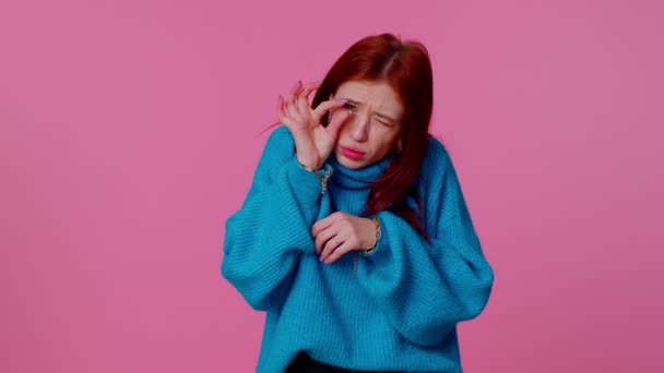 Rudowłosa urocza kobieta w swetrze pokazuje trochę gestu ze sceptycznym uśmiechem, pokazując minimalny znak - Materiał filmowy, wideo