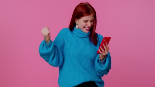 Šťastná vzrušená dívka použít mobilní telefon říct wow ano zjistil velkou výhru zprávy dělá vítězný gesto - Záběry, video