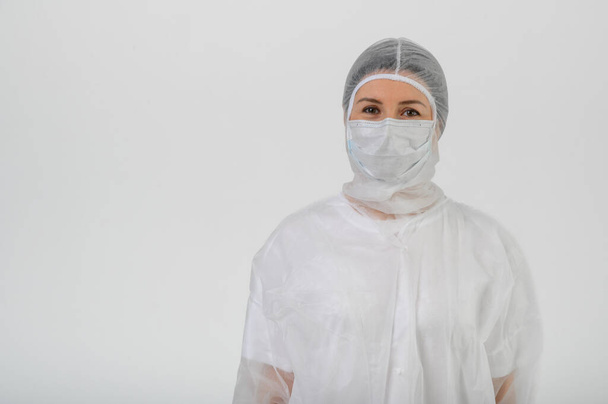 Лікар або медсестра в медичній сукні, масці та захисних рукавичках
 - Фото, зображення
