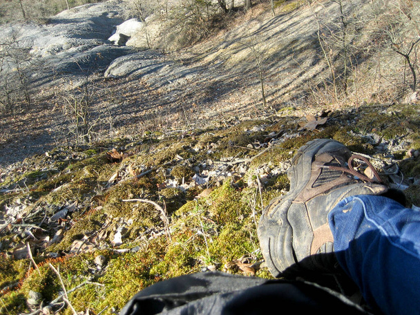 Foot in Hiking Boot Relaxing on the Ground - Valokuva, kuva