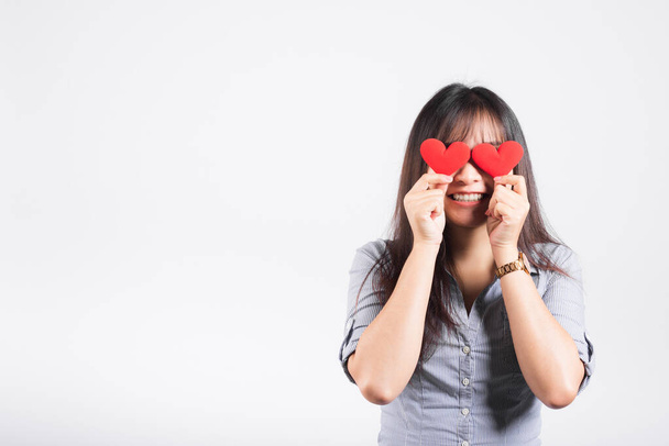 Woman standing her smile confidence cheerful cheery girl holding in hands two red heart symbol cards closing eyes isolated white background, Asian happy portrait beautiful young female valentine - Photo, Image