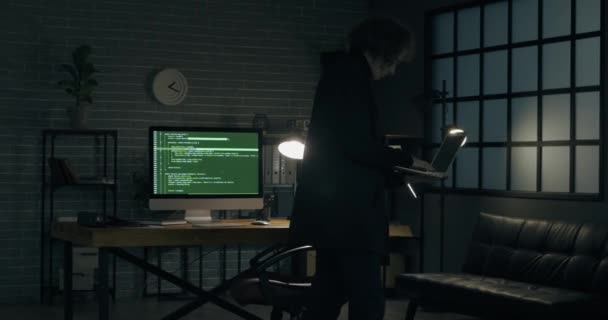 Programador usando laptop en cuarto oscuro - Imágenes, Vídeo