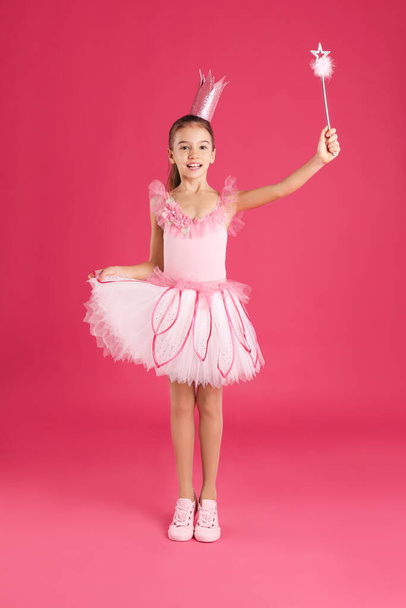 Cute girl in fairy dress with crown and magic wand on pink background. Little princess - Photo, image