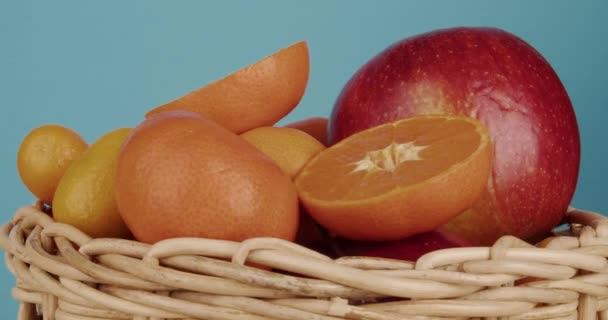 Korb mit frischen reifen Früchten auf blauem Hintergrund, Nahaufnahme - Filmmaterial, Video