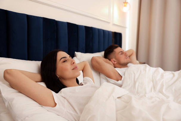 Lovely couple sleeping together in hotel room - 写真・画像